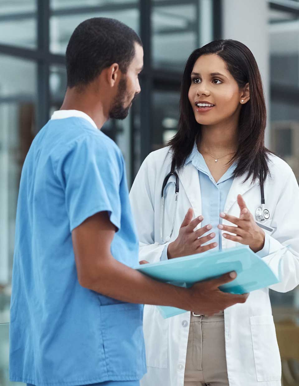 promo image for physician at a clinic discussing patient care with nurse